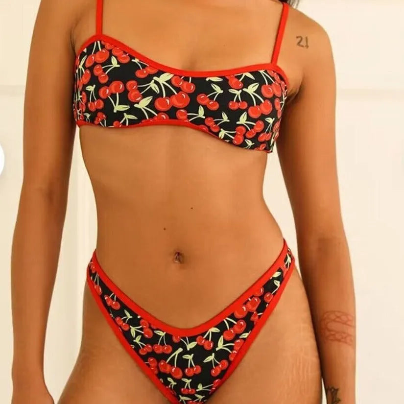 Women's cherry print tube top bikini swimsuit in brief style on a mannequin.