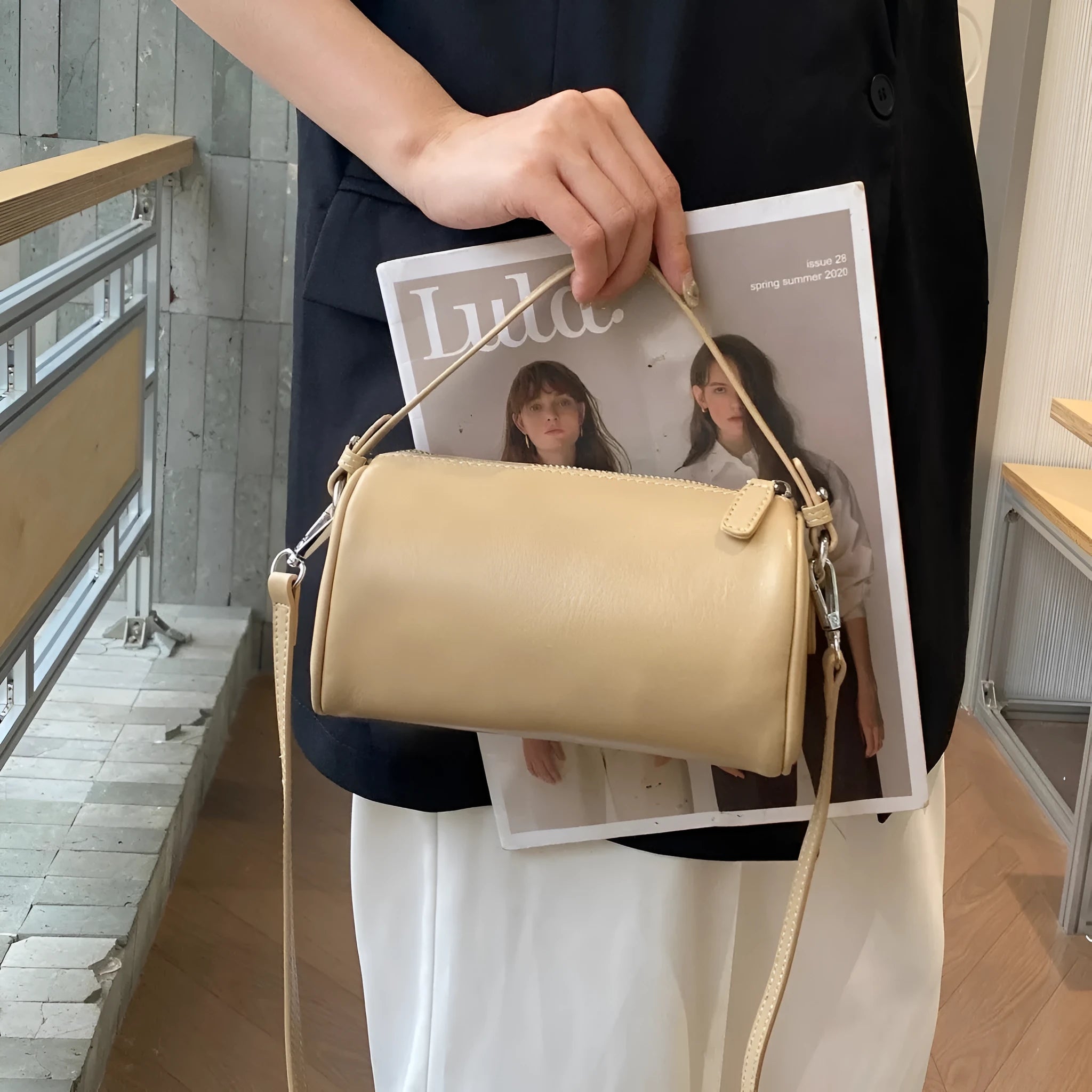 A soft genuine leather cylindrical crossbody bag for mobile phones in street style.