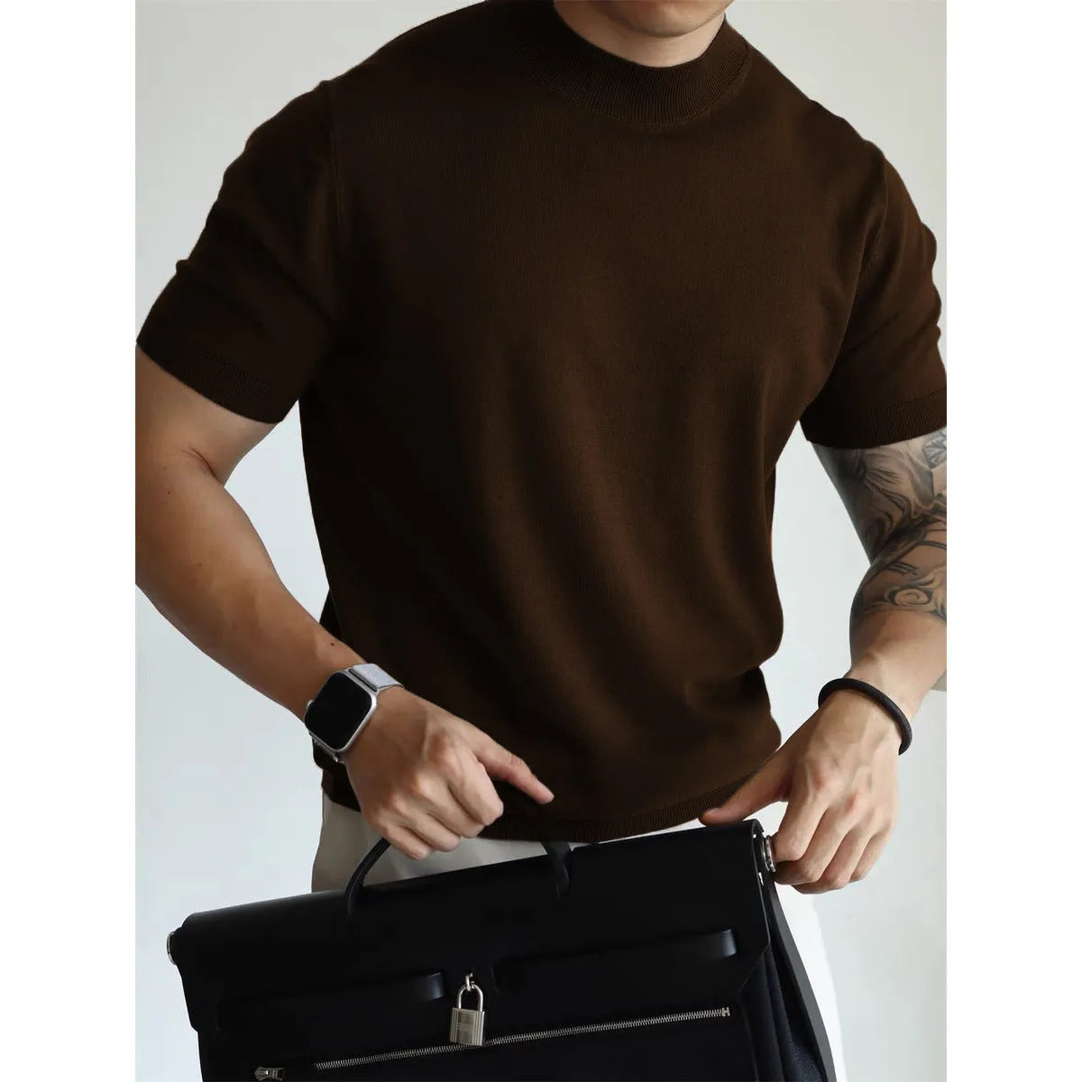 Man wearing a slim-fit solid colour polyester t-shirt, showcasing its lightweight knitwear construction.