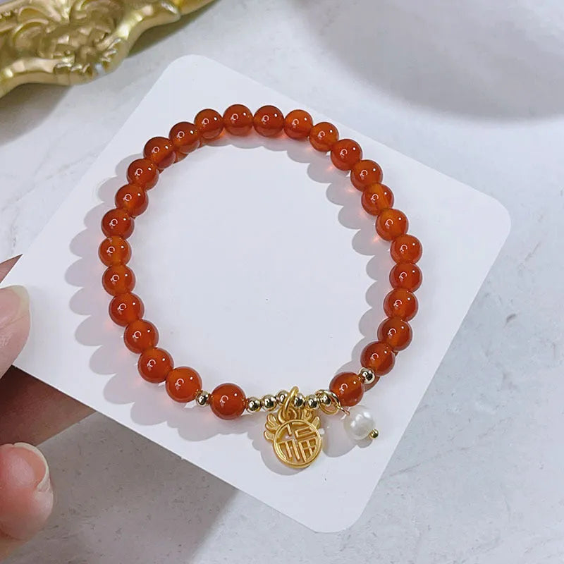 Handmade red agate bracelet with dragon and lucky bag Chinese designs for women.