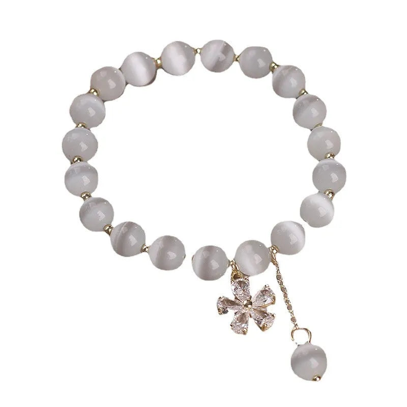 White cat's eye crystal bracelet with a silver flower tassel and safety buckle.