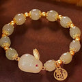 Women's black bracelet with green jade hare charm, fu character, and lily motif detail.