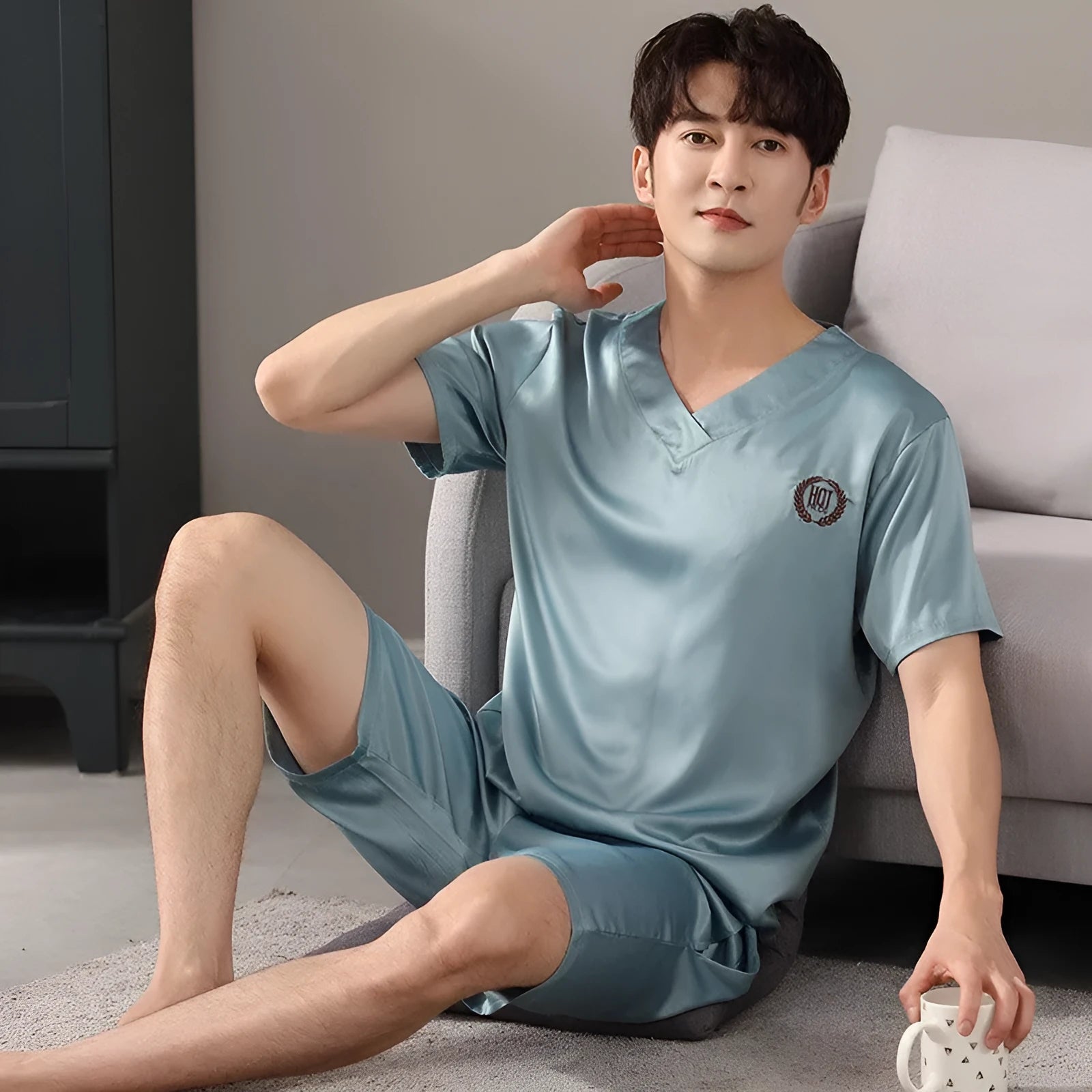 Man wearing a light grey ice silk short-sleeve pajama shirt and matching loose shorts.