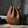 Vintage cowhide drawstring bundle wallet in chocolate brown showing sewing thread detail.