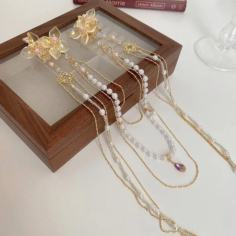 Gold women's hairpin with pearl, diamond acrylic details and a long tassel.