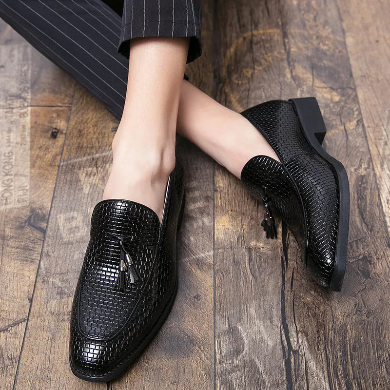 Men's black pointed slip-on business shoes with tassel detail on artificial PU upper.