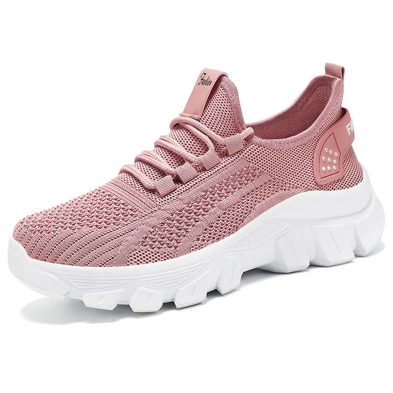Women's white flyknit casual sneakers with thick PVC sole and round toe, showing lace-up front.