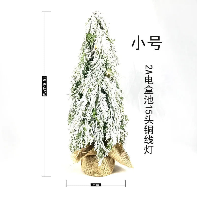 24-inch small artificial Christmas tree with snow spray decoration and built-in lights on desktop