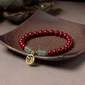 Gold cinnabar and copper wave bracelet in pumpkin or brand colour on wrist.