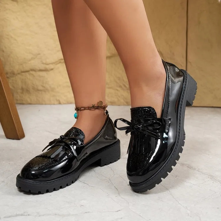 Women's black loafers with a decorative bow on the front, made from artificial PU.
