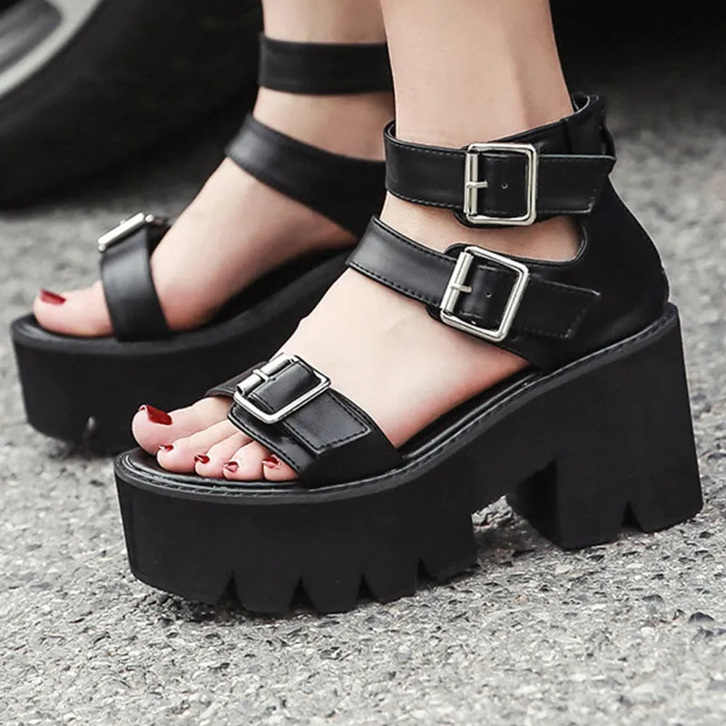 Black women's Roman style platform sandals with a chunky heel, round toe, back zipper, and decorative buckle.