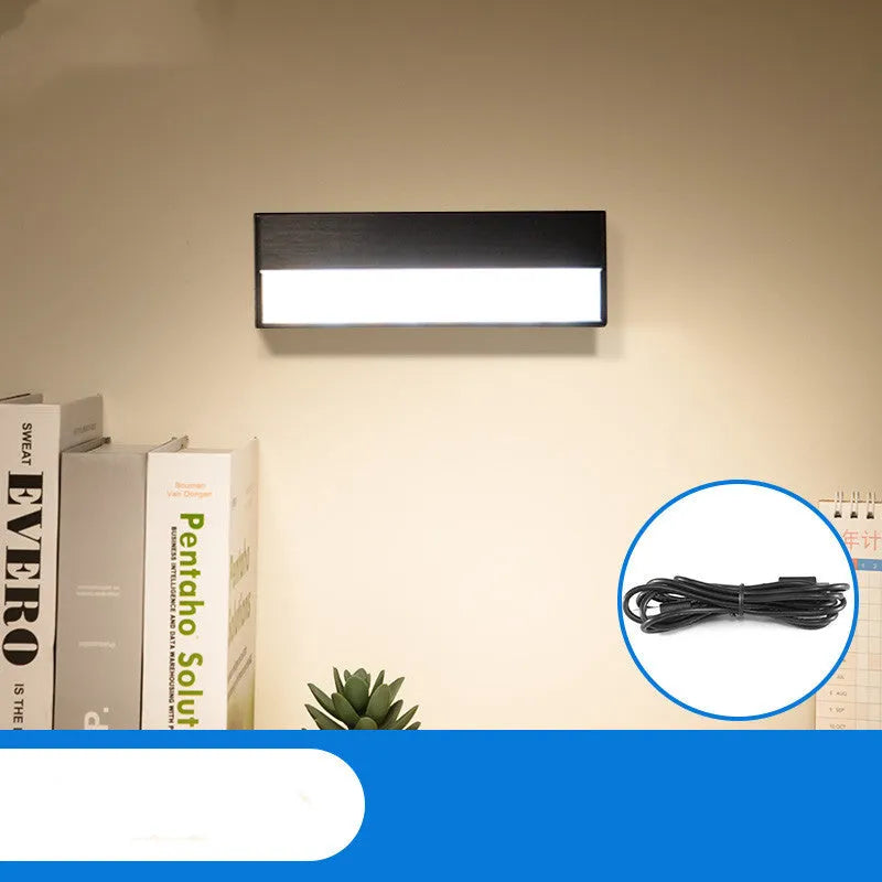 White and black portable magnetic LED desk lamp with adjustable dimming on a wooden desk