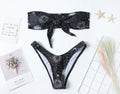 Black printed one-piece swimsuit with a backless design for women, made from nylon.