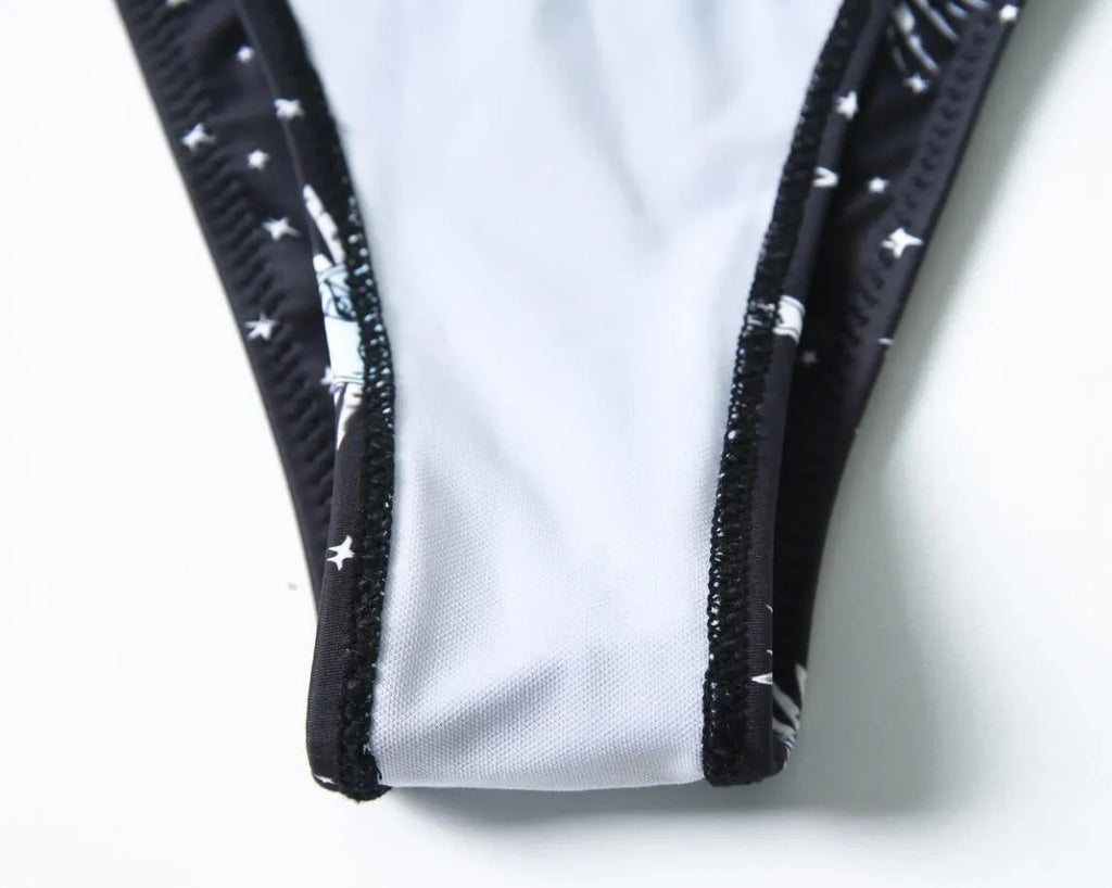 Black printed one-piece swimsuit with a backless design for women, made from nylon.