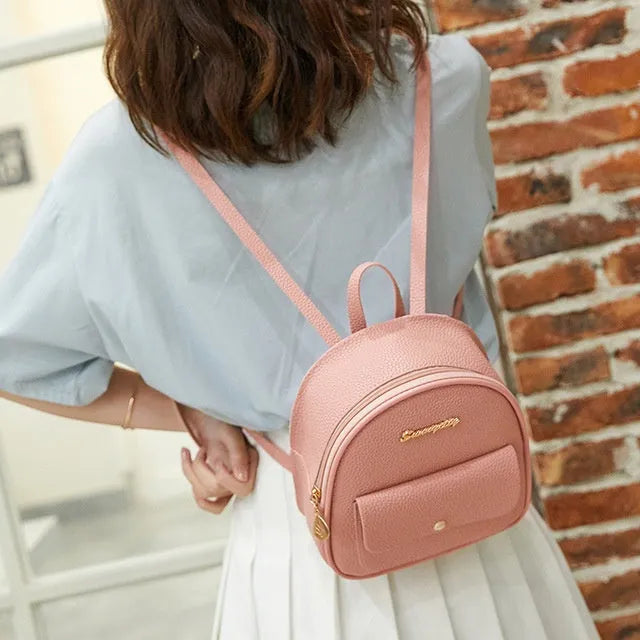 Women's small black PU leather backpack shoulder bag showing front zipper and dimensions