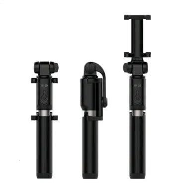 Black Bluetooth selfie stick tripod with extended rod, phone clamp, and deployed legs next to a smartphone