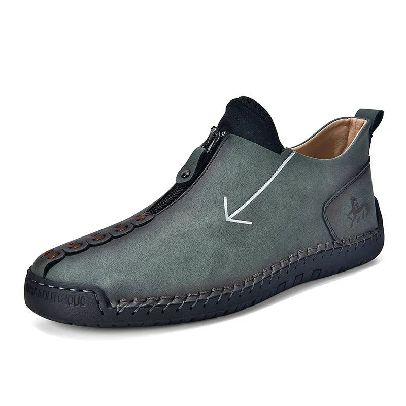 Men's black front-zip casual boots with round toe and low heel, showing the side zipper and rubber sole.