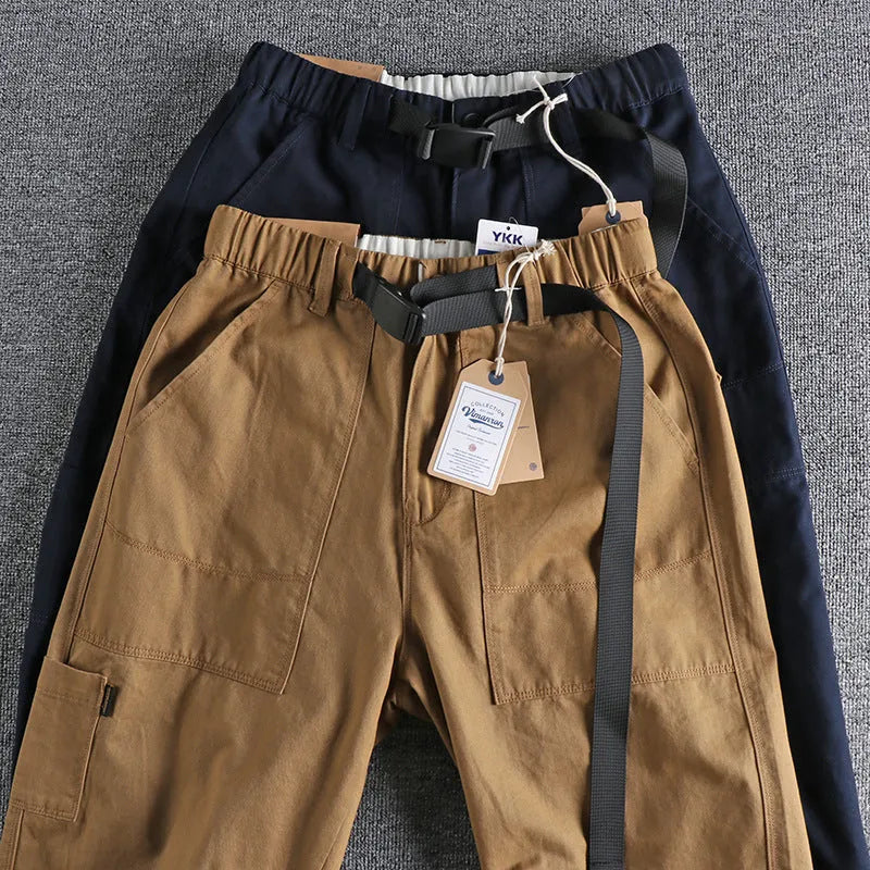 Men's khaki cotton work trousers with N I buckle belt and three-dimensional cut on a hanger.