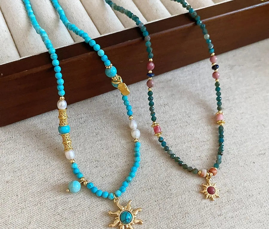 Stone sun pendant and freshwater pearl French court style necklace on a model
