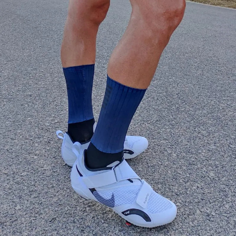 Pair of breathable chemical fibre blend athletic socks for cycling and running, shown in orange colour.