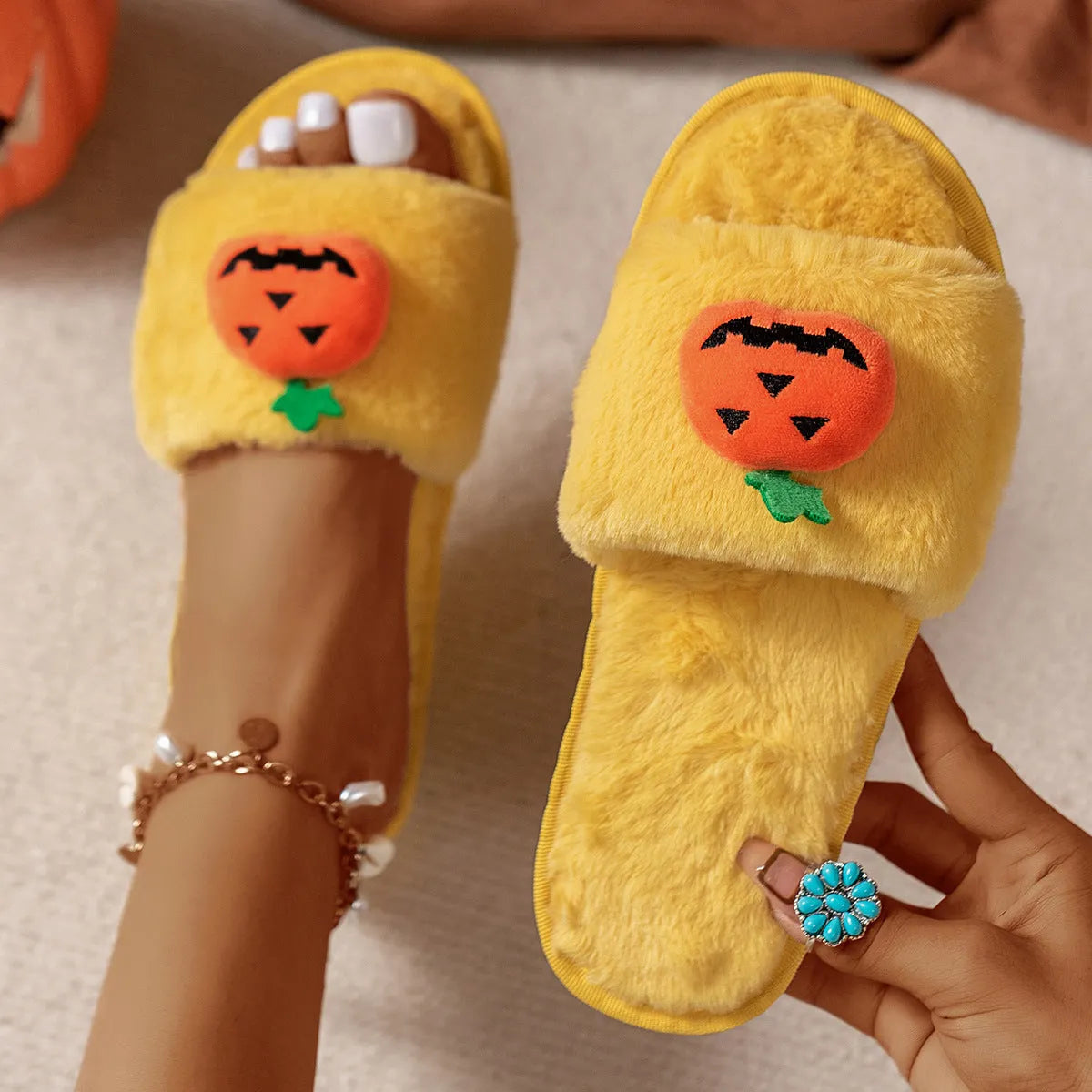 White and yellow Halloween pumpkin plush open toe slippers on anti-slip PVC sole.