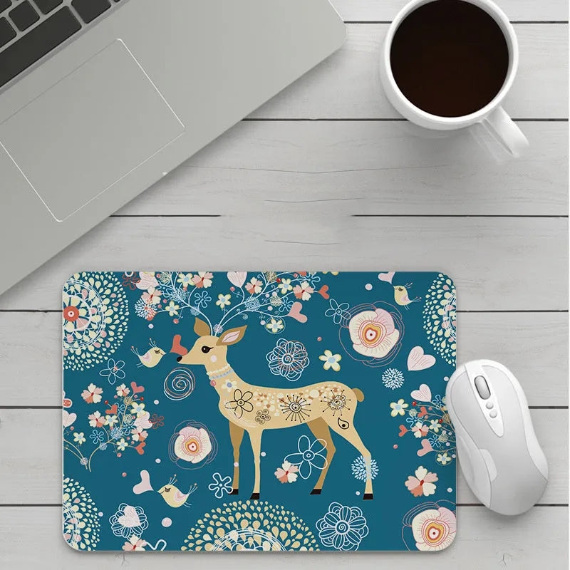 Custom cartoon design on a small black thickened mouse pad with stitching, shown on a desk.