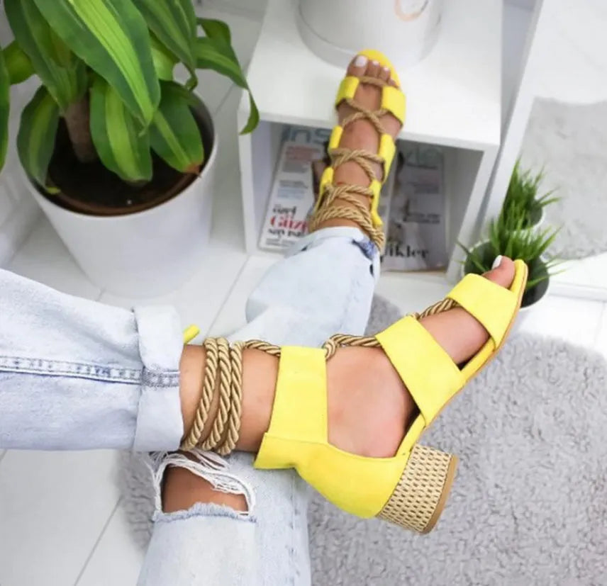 Women's beige suede sandals with fish-mouth toe, colour-matched pattern, and ankle strap on a thick heel.