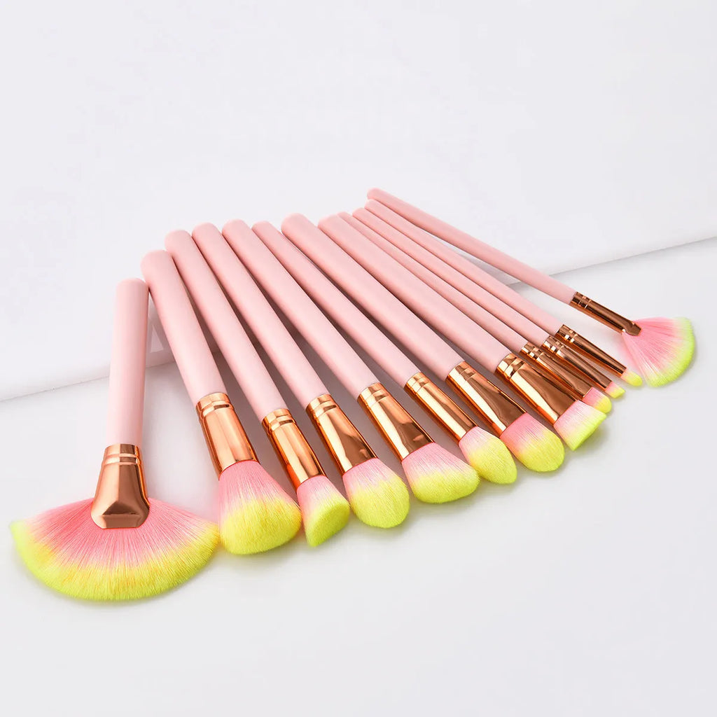 Pink 10-piece makeup brush set with nylon wool bristles and wooden handles laid out on a flat surface