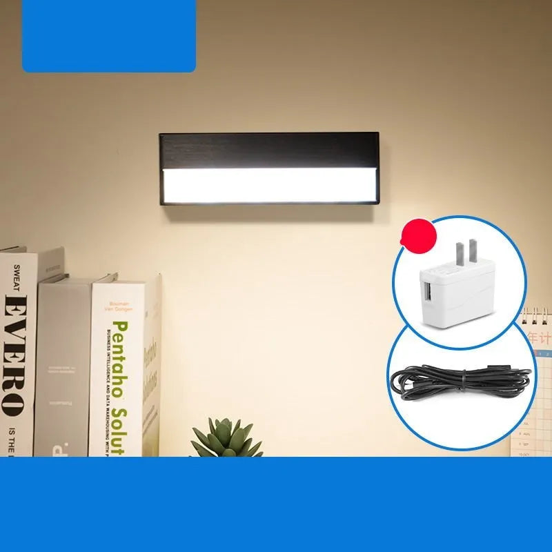 White and black portable magnetic LED desk lamp with adjustable dimming on a wooden desk