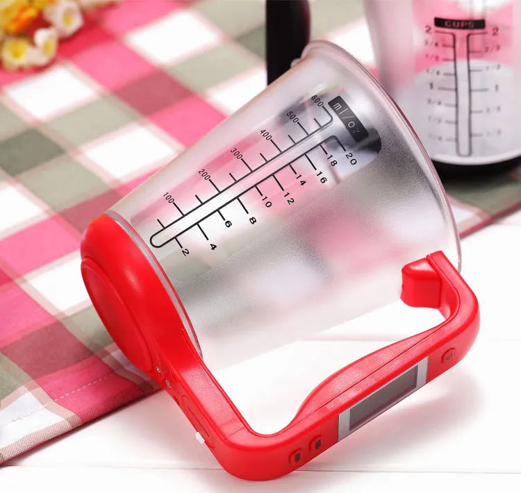 Green electronic kitchen scale measuring cup with digital LCD display on handle.