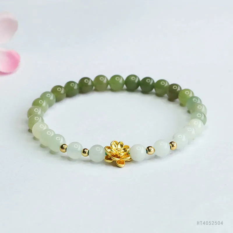 Hand-woven clear water gradient Hetian jade bracelet with flower-shaped beads on a white background.