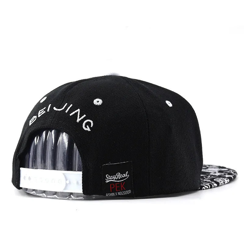 Cotton baseball cap with embroidered letters on the front, shown in black and white colours.