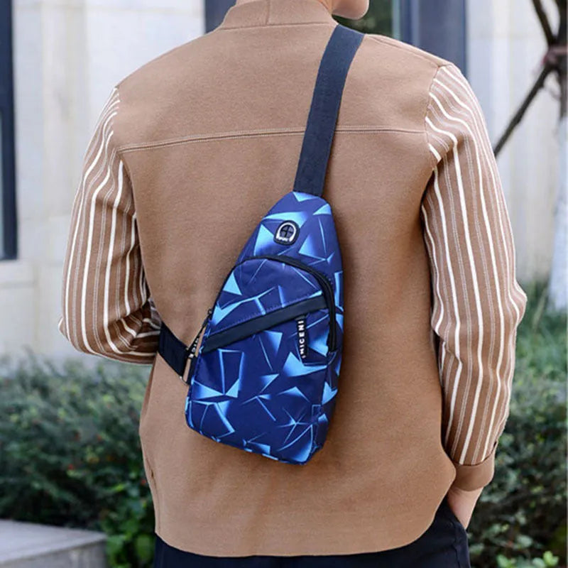 Men's blue Oxford cloth crossbody sling bag with earphone hole design showing zipper opening and letter print detail