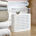 White recyclable electric dehumidifier box for cabinets with transparent top showing orange silica gel crystals.