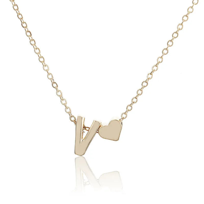 Gold alloy peach heart pendant with a letter charm on a chain.