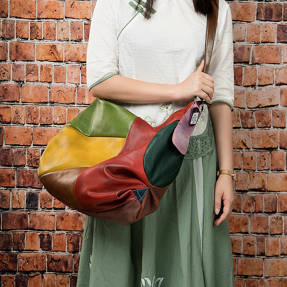 Brown hand-stitched cowhide leather travel bag shown as a crossbody bag.