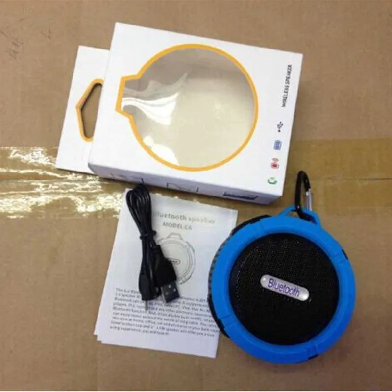 Portable waterproof Bluetooth speaker in multiple colours with a mountaineering buckle for bag attachment.