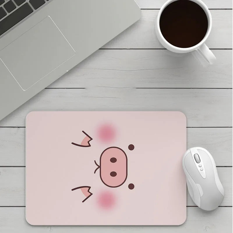 Custom cartoon design on a small black thickened mouse pad with stitching, shown on a desk.