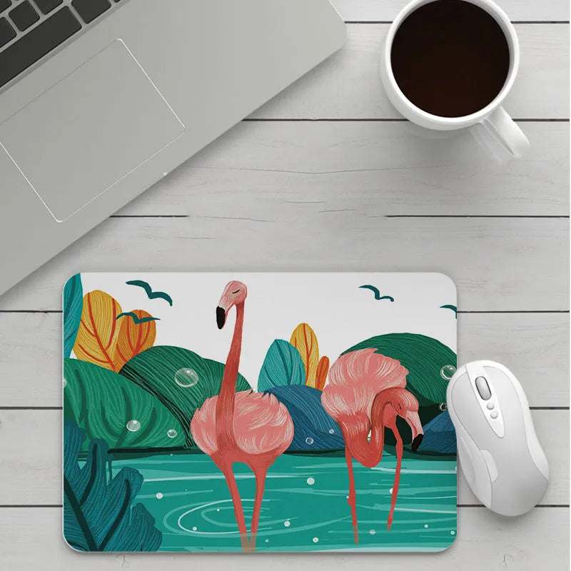 Custom cartoon design on a small black thickened mouse pad with stitching, shown on a desk.