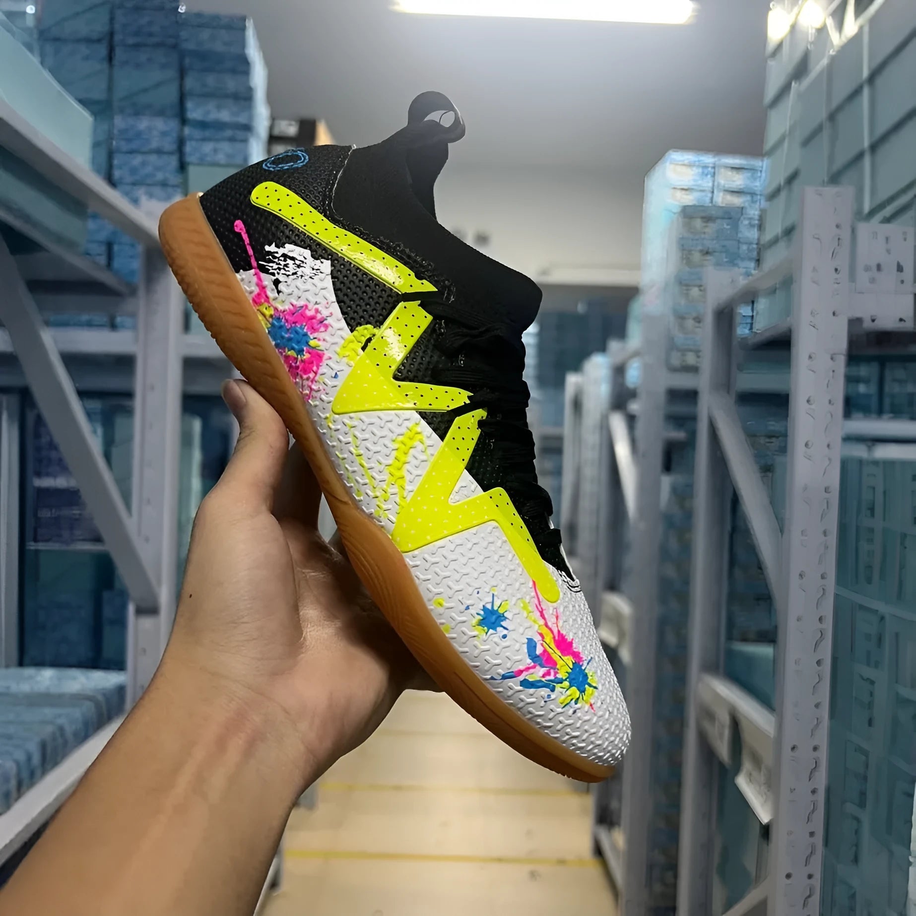 Adult low-top football boots with PVC upper and replaceable studs in black and yellow colourway