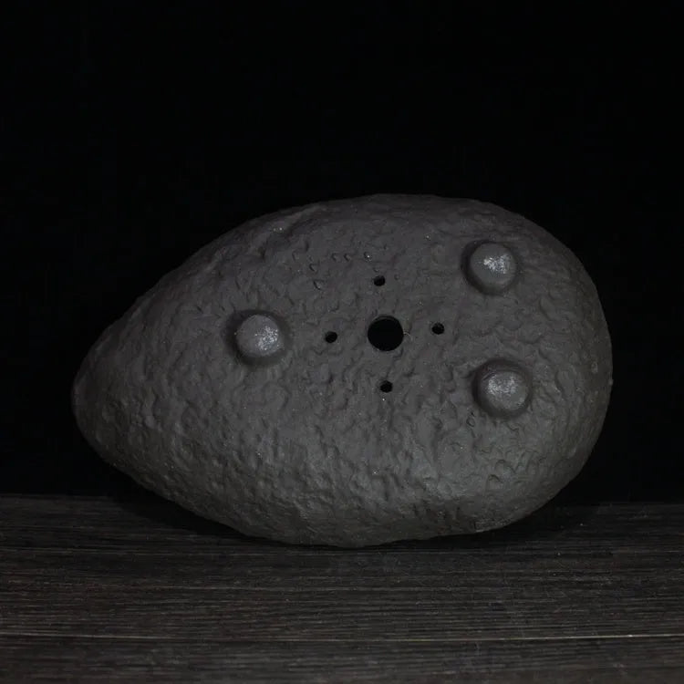 Handmade purple clay flower pot showing unique shape and natural clay texture