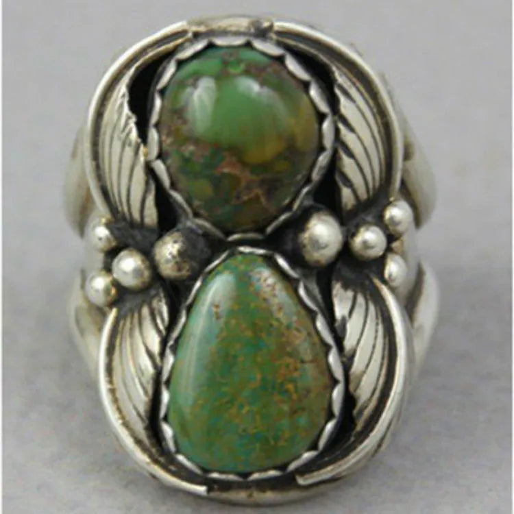 Close-up of a women's turquoise geometric ring with retro inlaid design on a hand.