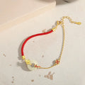 Women's koi peace buckle bracelet in 925 silver with electroplated gold finish on red rope