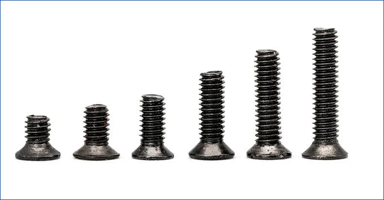 Bulk set of small black countersunk head machine screws for laptop repair on a white background.