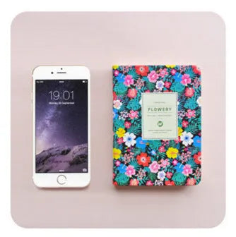 Green fabric imitation leather floral notepad open on a desk, showing custom logo printing and Daolin paper.