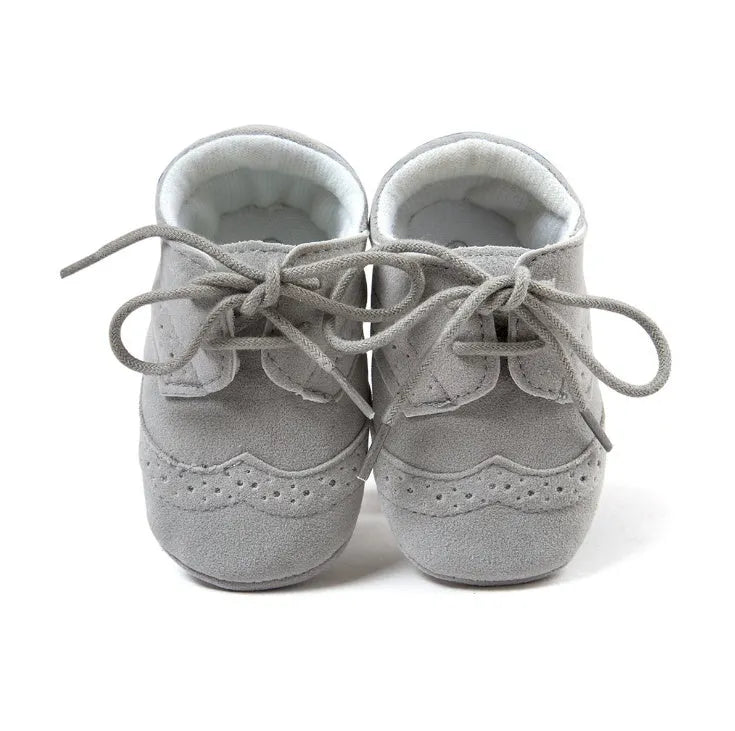 Vintage style soft-soled baby shoes for boys in synthetic leather, available in black, grey, light brown, and white.