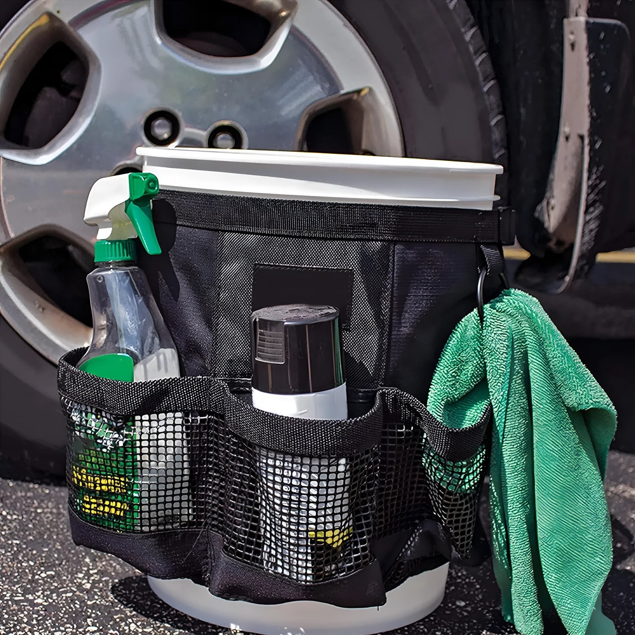 Black cylindrical polyester storage bag hanging on a 5-gallon barrel for outdoor tool organisation.