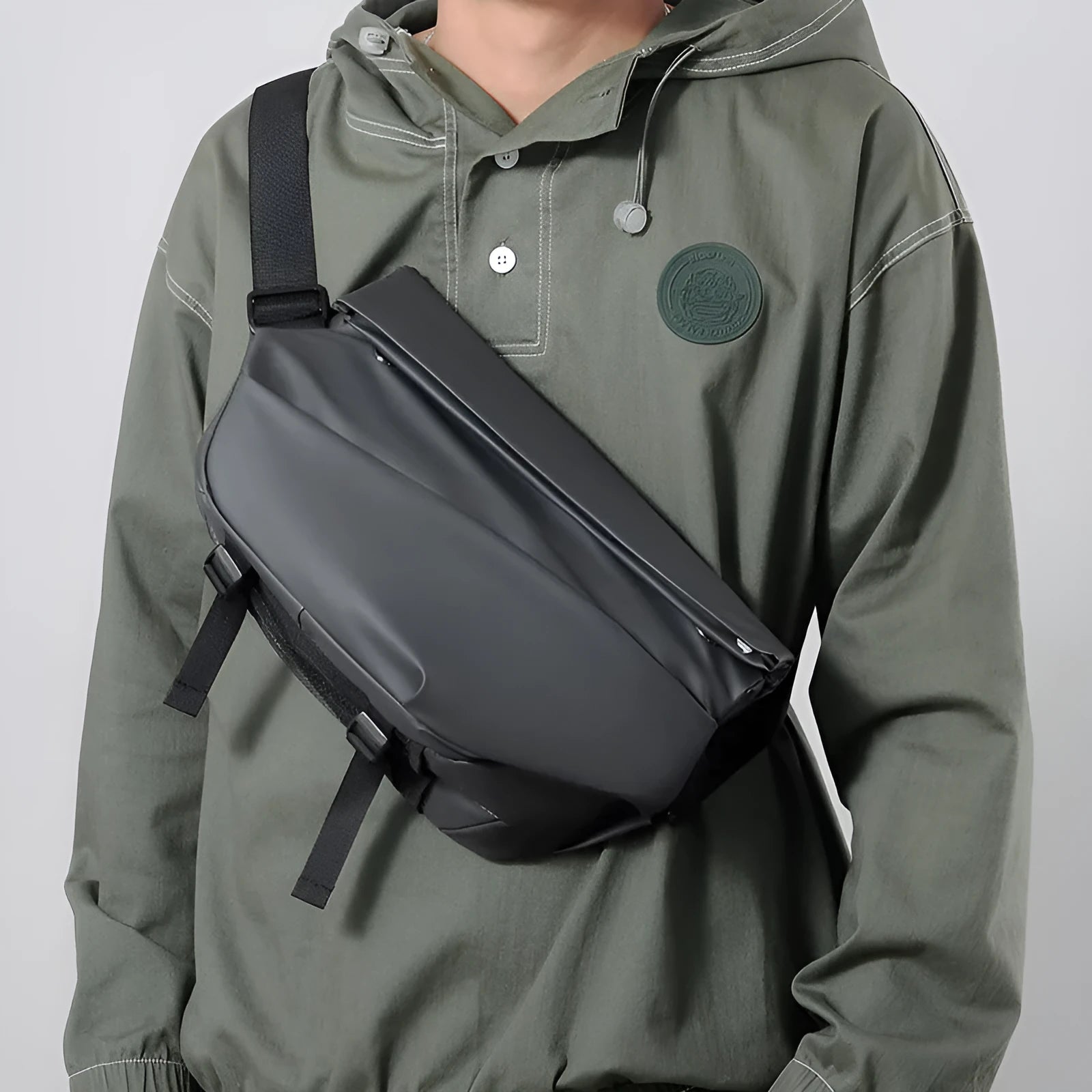 Men's grey PU crossbody chest bag showing zipper opening and adjustable shoulder strap.