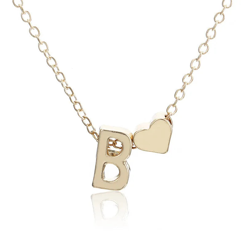 Gold alloy peach heart pendant with a letter charm on a chain.