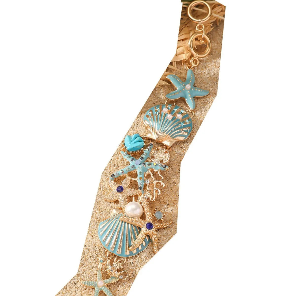 Close-up of a women's alloy bracelet featuring a boat anchor, marine shell, and starfish charms in a coral blue colour.
